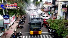 Tampak satu unit kendaraan water cannon tengah menyemprotkan cairan disinfektan kesekitar area kantor Pemkab Jember.