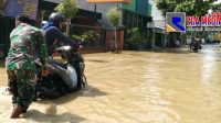 Aksi Babinsa Dorong Motor Mogok Ditengah Banjir Sampang