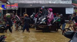 Tampak sejumlah pengendara motor ada diatas gerobak menerobos banjir di jalan raya Blega.