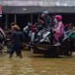 Tampak sejumlah pengendara motor ada diatas gerobak menerobos banjir di jalan raya Blega.
