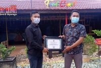 Ketua Jurnalis Center Pamekasan (Mulyadi Izhaq) saat memberikan reward/penghargaan kepada Manager Bani Food Court (Luthfiadi).
