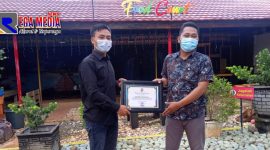 Ketua Jurnalis Center Pamekasan (Mulyadi Izhaq) saat memberikan reward/penghargaan kepada Manager Bani Food Court (Luthfiadi).