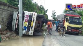 Tampak truk menimpa sebagian rumah warga dan arus lalu lintas dilokasi kejadian terjadi kemacetan.