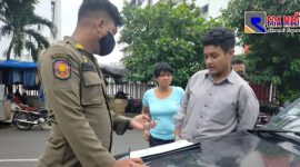 Anggota Satpol PP saat memberikan sanksi kepada pelanggar prokes.