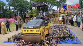 Bupati Pamekasan (Baddrut Tamam) saat melindas ribuan botol miras dengan alat berat Tandem Roller Mini.