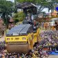Bupati Pamekasan (Baddrut Tamam) saat melindas ribuan botol miras dengan alat berat Tandem Roller Mini.