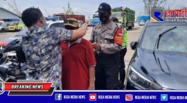 Panit 1 Unit Reskrim Polsek Pabean Cantikan saat mengenakan masker kepada warga yang tidak memakai masker.