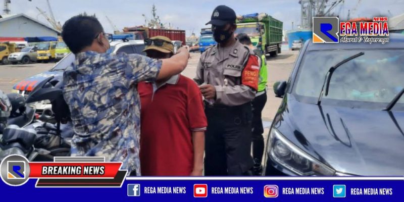 Panit 1 Unit Reskrim Polsek Pabean Cantikan saat mengenakan masker kepada warga yang tidak memakai masker.
