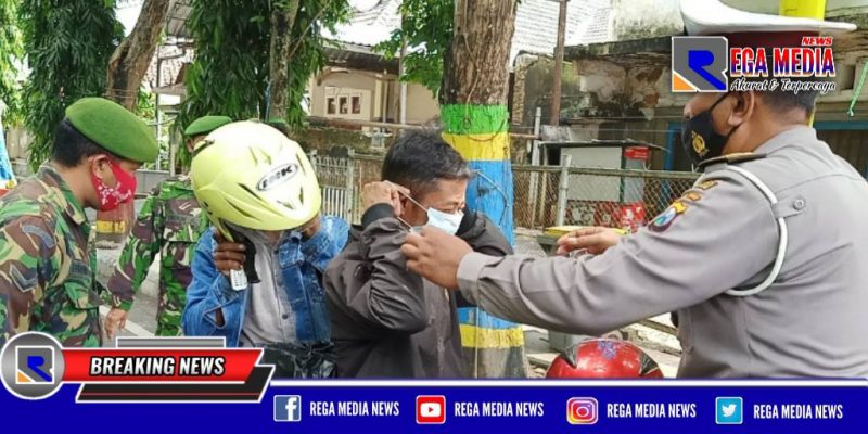 Polres Pamekasan bersama tim gabungan saat membagikan masker kepada pengguna jalan yang melintas selama PPKM.