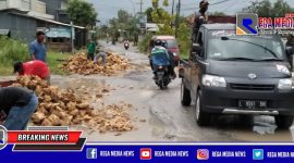 Tampak lalu lalang kendaraan ditengah sejumlah warga Arosbaya Bangkalan bergotong royong memperbaiki jalan rusak dan berlubang.