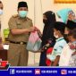 Direktur Utama Rega Media (Moh. Fauzan) bersama Sekdakab Sampang (H. Yuliadi Setiyawan) saat memberikan santunan anak yatim.