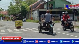 Terlihat pengendara bentor dan motor saling berpapasan menghindari drum yang ada di tengah jalan raya Jl. Imam Bonjol, Sampang.