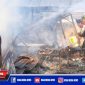 Tampak sejumlah warga dan petugas tengah memadamkan api yang membakar sejumlah kios.