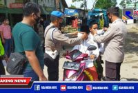 Anggota Polres Sampang saat mengenakan masker kepada pengendara yang  terjaring penyekatan dan operasi yustisi prokes.