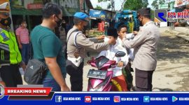 Anggota Polres Sampang saat mengenakan masker kepada pengendara yang  terjaring penyekatan dan operasi yustisi prokes.