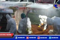 Tampak anggota PMI Sampang menggunakan APD lengkap saat pemulasaraan jenazah positif Covid-19.