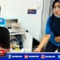 Tersangka BS saat diamankan polisi, tampak karyawan Indomaret menunjukkan tempat penyimpanan rokok yang dibobol.