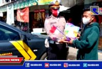 Kanit Lantas Polsek Kenjeran (Ipda Supriyono) saat memberikan sembako beras.