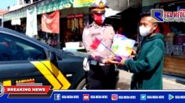 Kanit Lantas Polsek Kenjeran (Ipda Supriyono) saat memberikan sembako beras.