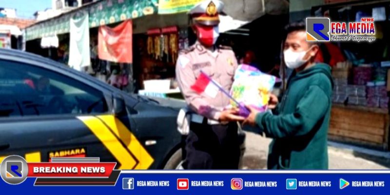 Kanit Lantas Polsek Kenjeran (Ipda Supriyono) saat memberikan sembako beras.