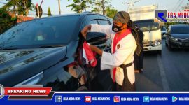 Ketua umum perguruan pencak silat Surban Putih saat mengikatkan bendera merah putih ke kendaraan.