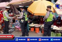 Anggota Unit Lantas Polsek Krembangan saat membagikan masker kepada pedagang Pasar Kalianak Timur Lebar, Surabaya.