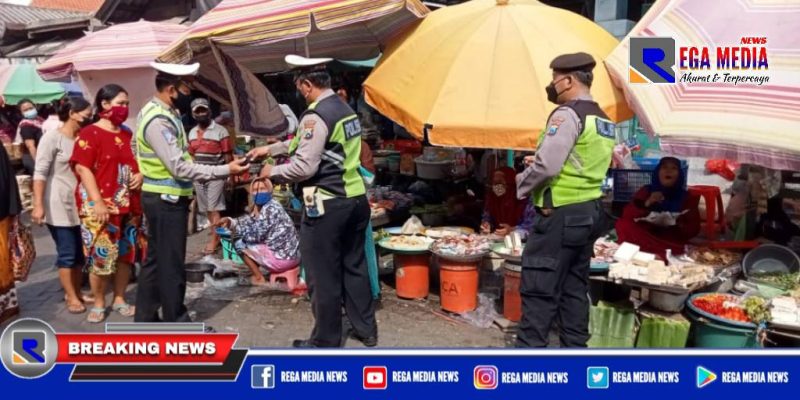 Anggota Unit Lantas Polsek Krembangan saat membagikan masker kepada pedagang Pasar Kalianak Timur Lebar, Surabaya.
