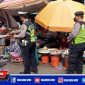 Anggota Unit Lantas Polsek Krembangan saat membagikan masker kepada pedagang Pasar Kalianak Timur Lebar, Surabaya.