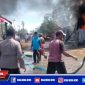 Terlihat petugas kepolisian dan warga mencoba memadamkan api yang membesar.