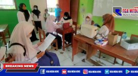 Caption: petugas kesehatan tengah melakukan pemeriksaan dan vaksinasi kepada sejumlah pelajar.