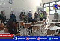 Caption: Polsek Mulyorejo saat pengecekan disiplin prokes di SMPN 45 Mulyorejo, Surabaya.