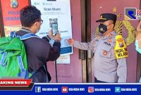 Caption: Kapolsek Semampir (AKP Ari Bayuaji) memberikan arahan menggunakan barcode aplikasi pedulilindungi.