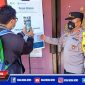 Caption: Kapolsek Semampir (AKP Ari Bayuaji) memberikan arahan menggunakan barcode aplikasi pedulilindungi.