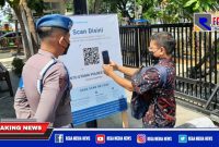 Caption: seorang pengunjung tengah scan barcode peduli lindungi yang hendak masuk ke Mapolres Sampang.