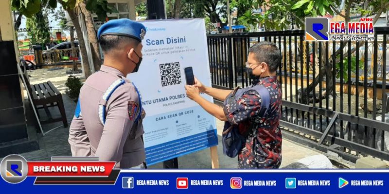Caption: seorang pengunjung tengah scan barcode peduli lindungi yang hendak masuk ke Mapolres Sampang.
