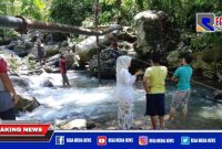 Caption: tampak warga berada di lokasi terputusnya pipa PDAM.