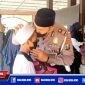 Caption: Kasat Lantas Polres Pelabuhan Tanjung Perak tengah mencium kening anak yatim piatu.