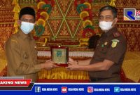 Caption: Bupati Aceh Selatan saat menyerahkan cinderamata kepada Kepala Kejaksaan Tinggi.