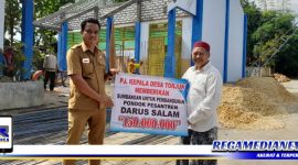 Caption: secara simbolis, PJ Kades Torjun (Achmad Fadil) serahkan dana kepada pengasuh pon-pes tahfidz Darus Salam (KH. Mohammad Aunul Abied Syah).