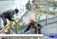 Caption: Bupati Asahan (H. Surya) saat tanam pohon mangrove.