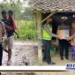 Caption: tampak anggota Satlantas Polres Sampang membawa dan memberikan bantuan paket sembako kepada warga kurang mampu.