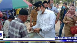 Caption: Bupati Bangkalan (R Abdul Latif) menyerahkan bantuan uang kepada salah satu pedagang kaki lima.