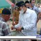 Caption: Bupati Bangkalan (R Abdul Latif) menyerahkan bantuan uang kepada salah satu pedagang kaki lima.