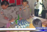 Caption: anggota Polsek Kota Barat, Kota Gorontalo, saat mengamankan sejumlah botol miras oplosan.