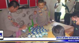 Caption: anggota Polsek Kota Barat, Kota Gorontalo, saat mengamankan sejumlah botol miras oplosan.