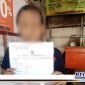 Caption: salah satu orang tua korban pencabulan di Ploso Surabaya, menunjukkan surat laporan polisi.