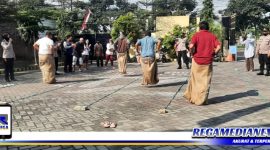 Caption: suasana kemeriahan perlombaan balap karung di halaman Mapolsek Benowo.