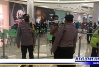 Caption: anggota Polsek Mulyorejo tampak memantau pelaksanaan vaksinasi di gerai vaksin Galaxy Mall 3 Surabaya.