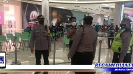 Caption: anggota Polsek Mulyorejo tampak memantau pelaksanaan vaksinasi di gerai vaksin Galaxy Mall 3 Surabaya.