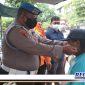 Caption: anggota Provost Polres Pelabuhan Tanjung Perak saat membagikan masker kepada warga.